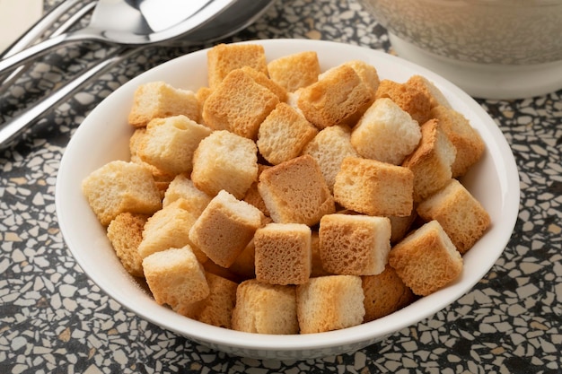 White bowl with croutons for seasoning close up