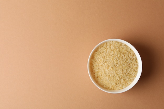 White bowl with rice on craft surface