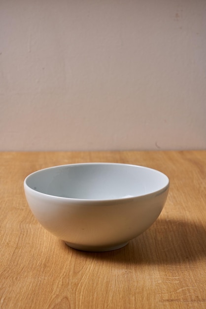 A white bowl on a wooden table