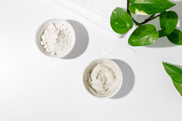 Photo white bowls with white cosmetic clay - powder bentonite facial mask skincare beauty concept