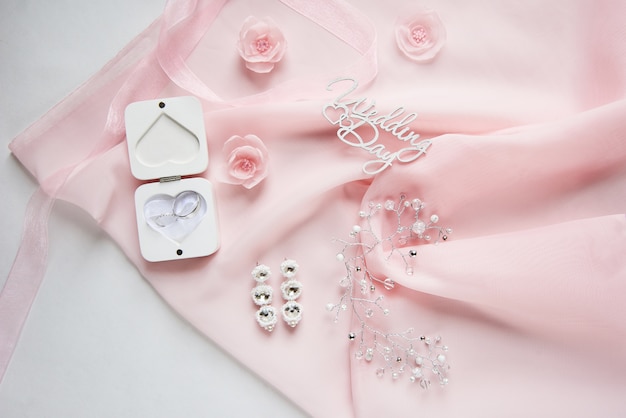 White box for wedding rings on pink chiffon with wedding accessory