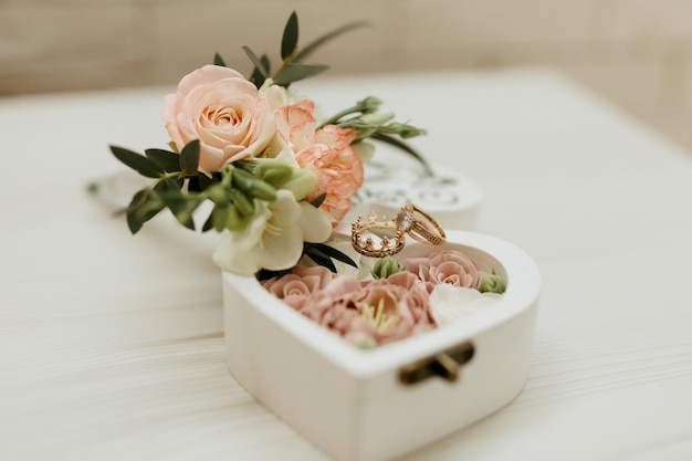 A white box with a heart shape and pink flowers inside