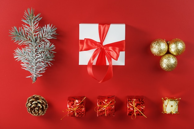 White box with padark and red bow around Christmas decorations with spruce branches