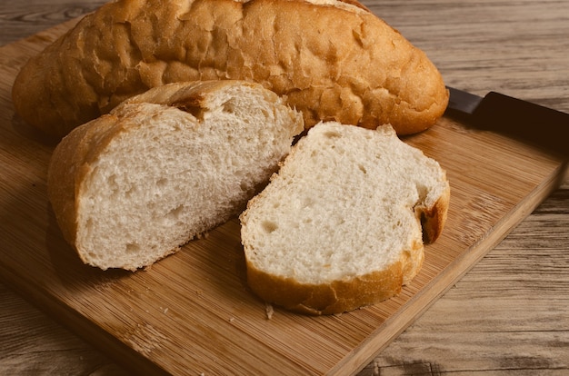 White bread cut on cutting board and wooden table