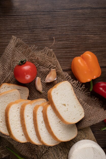 Foto pane bianco affettato e servito con verdure