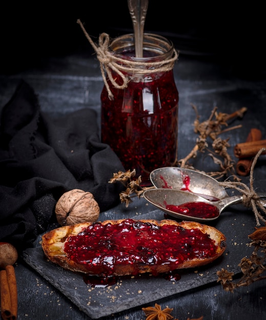 White bread toast spread with raspberry jam