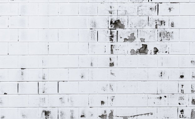 White brick wall texture background. Old white brick wall with peeling paint. Empty old brick wall. Home exterior and interior decoration concept.