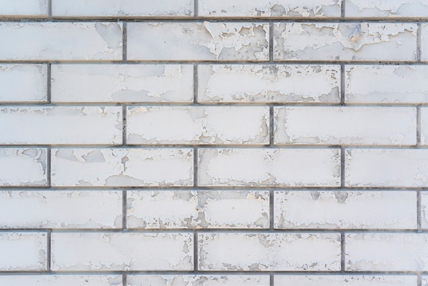 White brick wall with peeling paint. Brick space. Close up