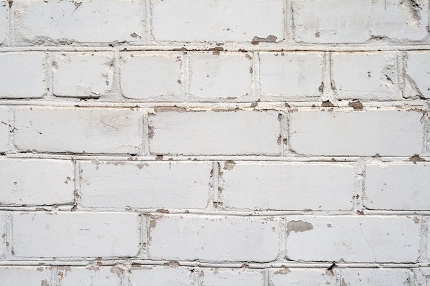 White brick wall with peeling paint