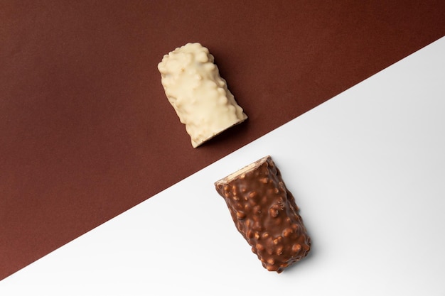 White and brown chocolate bars on contrasting backgrounds top view