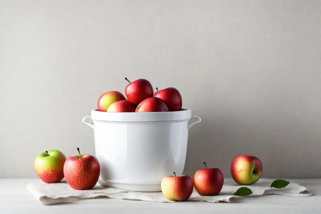 a white bucket with a bowl of apples on it and a white bowl with a few leaves on it