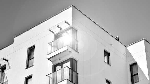 a white building with a balcony and a balcony with a sun shining on the top.