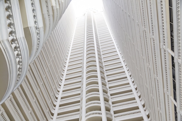 White building with many floors that view from below.