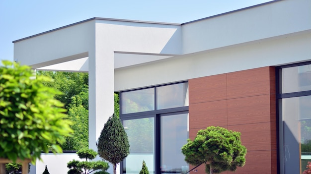 A white building with a white roof and a tree in front of it