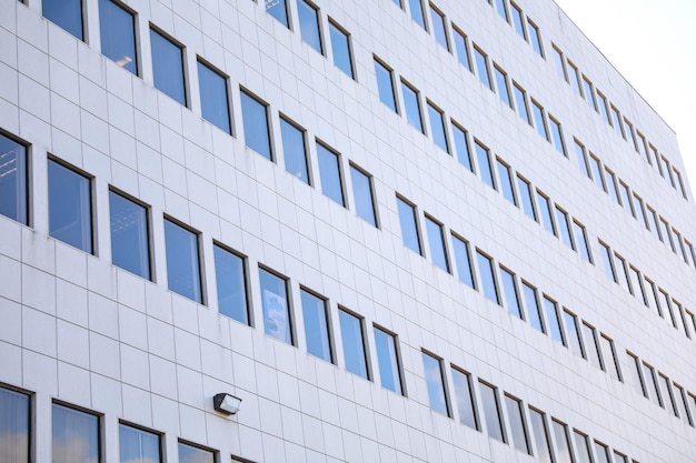 A white building with windows and a blue sky in the background