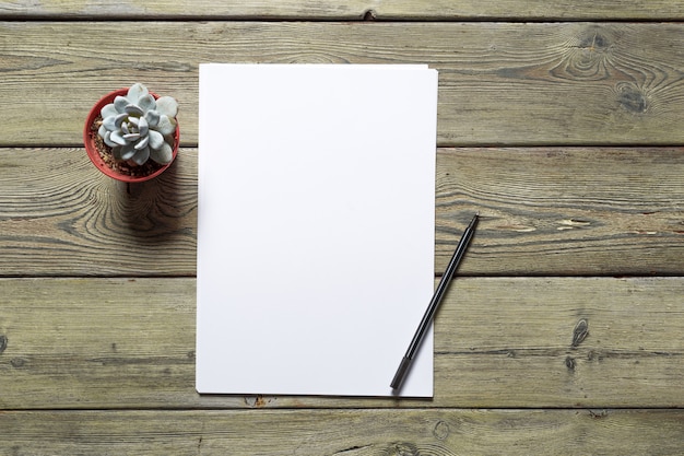 White business card on wooden table. Blank portrait A4.