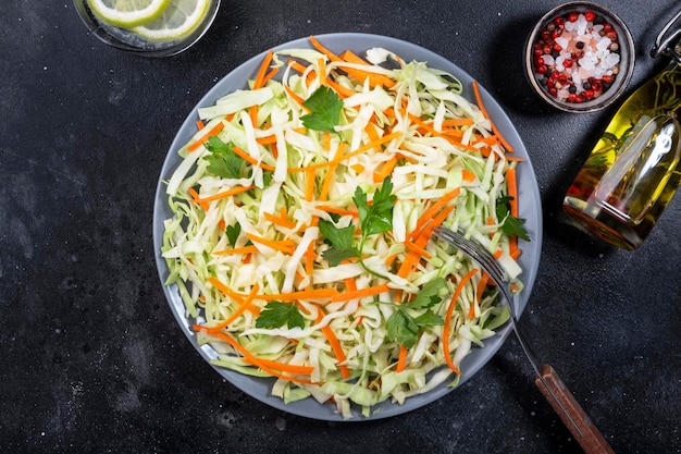 White cabbage salad coleslaw with carrot on grey kitchen table background Top view copy space