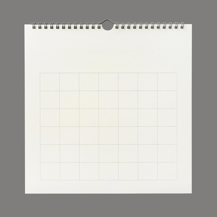 Photo white calendar paper background with grid line of table. wall calendar on gray background. close-up.