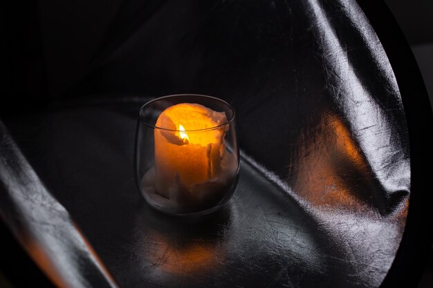 Белая свеча горит в миске на серебряном фоне