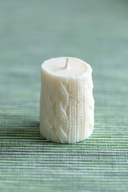 사진 녹색 배경 소프트 포커스 사진에 니트 패턴이 있는 흰색 촛불