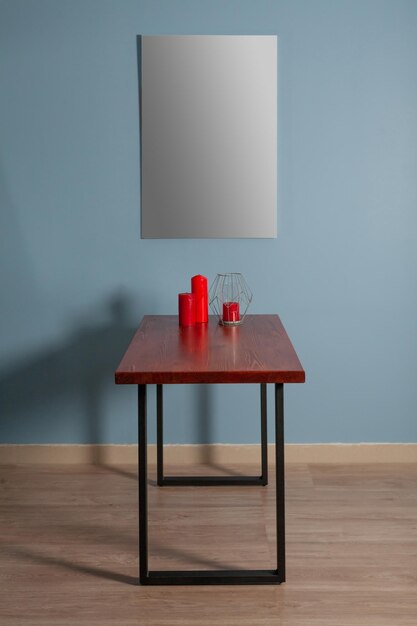 사진 내부 모형의 파란색 벽에 나무 테이블에 그림을 그리기 위한 흰색 캔버스