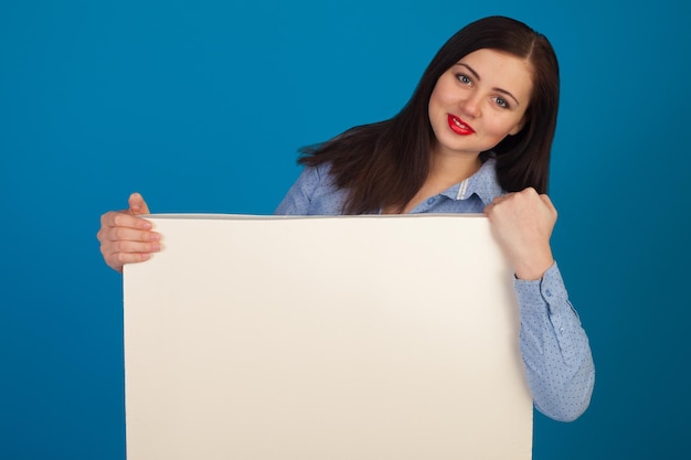 White canvas is held by woman against of blue background