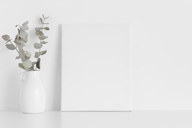 White canvas mockup with an eucalyptus on the table