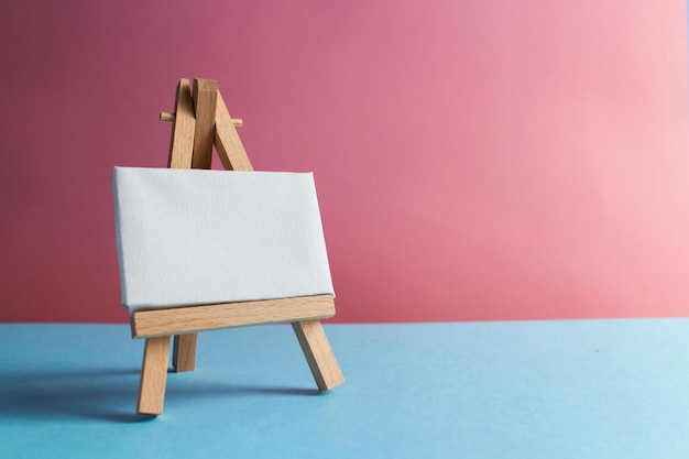 Photo white canvas for painting on an easel on a blue background