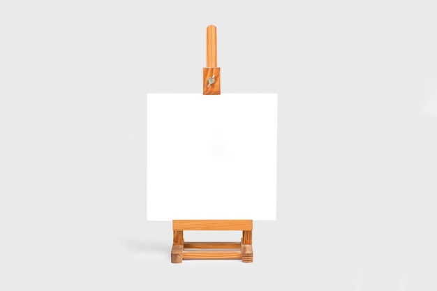 White canvas with copy space on a wooden easel on a gray background