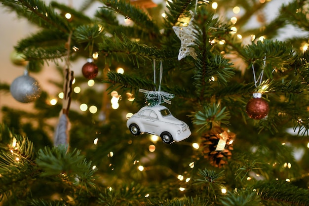 ツリーにぶら下がっている白い車とクリスマスのおもちゃ