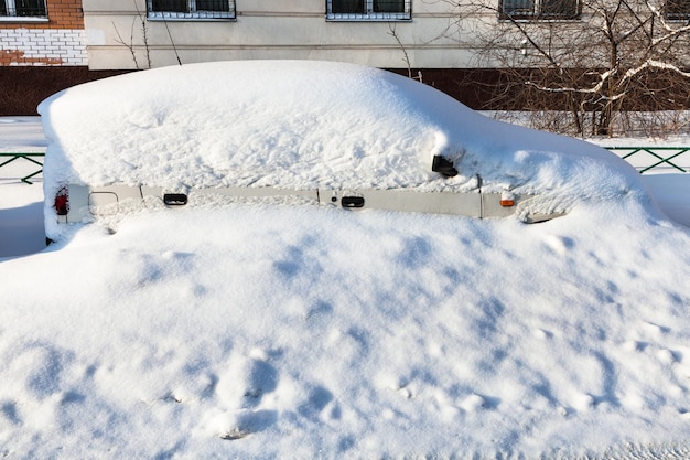 White car covered with snow in parking lot