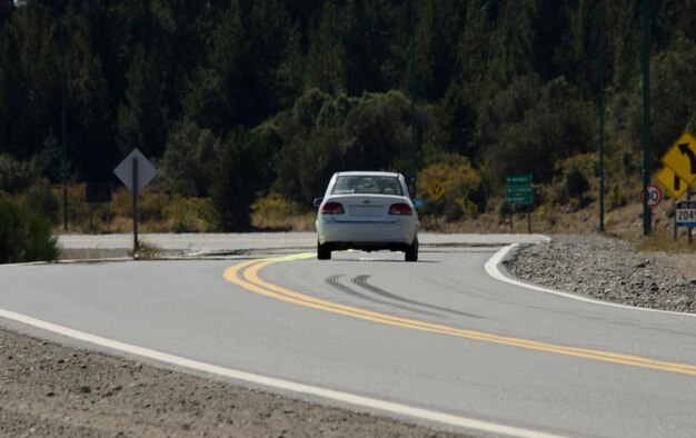 white car driving on the road with asphalt bariloche ring road