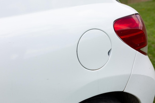 A white car with a gas cap on the side