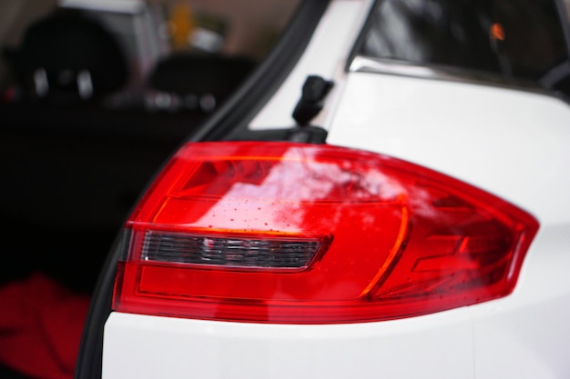 White car with red headlight and open door