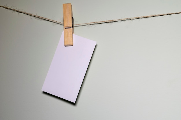 White card hanging on the wire with wooden pin