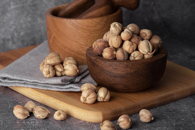 White cardamom in a wooden spoon and bowl Dry cardamom spice Cardamom seeds macro shot