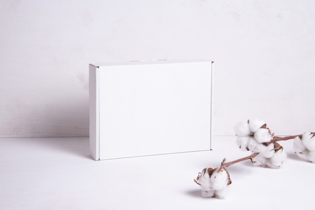 White cardboard box decorated with cotton flower branch