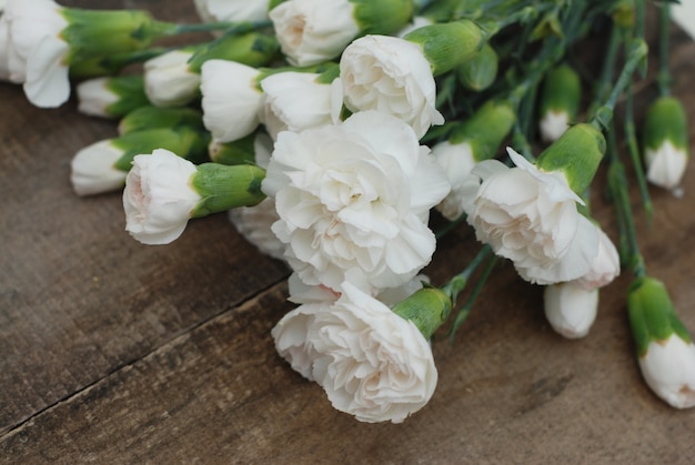 White carnation flower bouquet. Isolated rustic wooden.