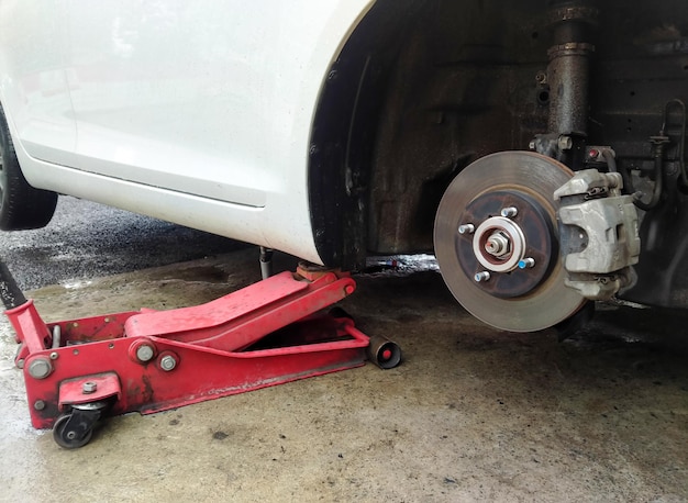 White cars change wheels using a lifting jack