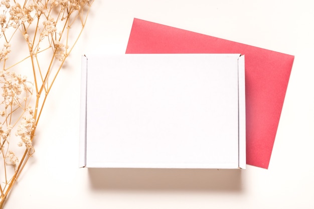 Белая картонная коробка, украшенная сушеной травой, плоская планировка