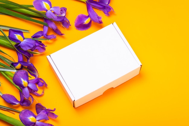 White carton cardboard box embellished with fresh iris flowers