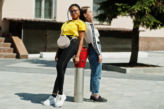 White caucasian girl and black African American together near fire hydrant. World unity, racial love, understanding in tolerance and races diversity cooperation.