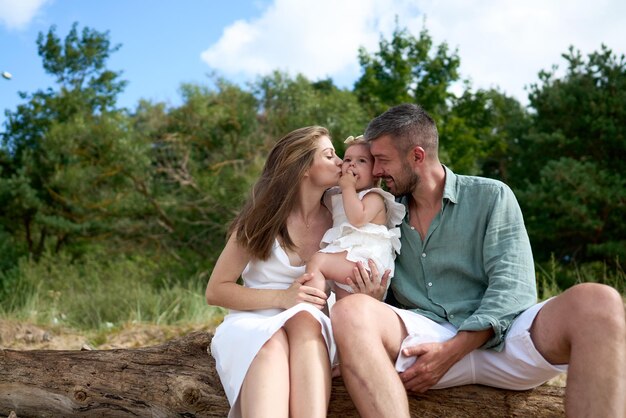 The white caucasian parents kissing their baby girl baltic sea latvia