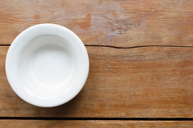 White ceramic bowl on the vintage wooden table