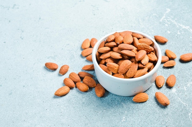 White ceramic bowl with almonds on rustic table Healthy snacks Nuts