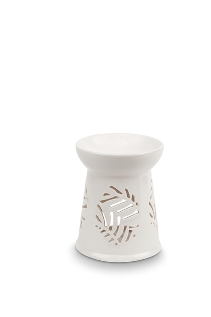 A white ceramic candle holder with a leaf design on the bottom.