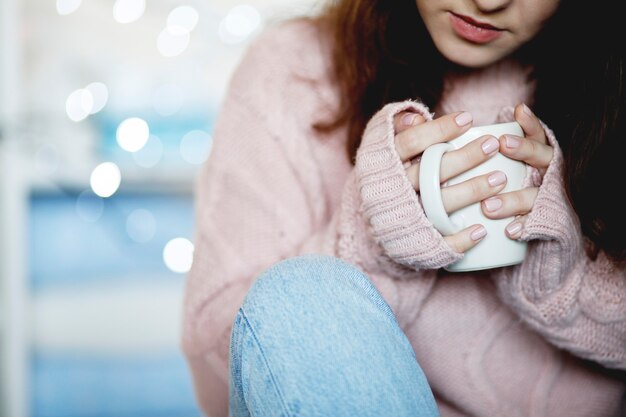 女性の手に白いセラミックコーヒーマグ