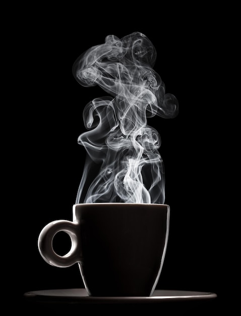 Photo white ceramic cup of fresh steaming fragrant aromatic morning hot coffee over black background. smoke from hot coffee.