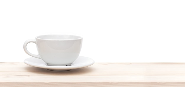 White ceramic cup or mug on wooden table in front of white background, space for text