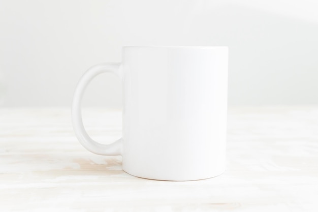 Фото Белая керамическая чашка на столе макет кружки спереди пустой шаблон для рисования дизайн места